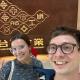 Zoe Friese and Tim Schütz smiling in front of the corporation's logo on the first floor of the Formosa Plastics Museum.